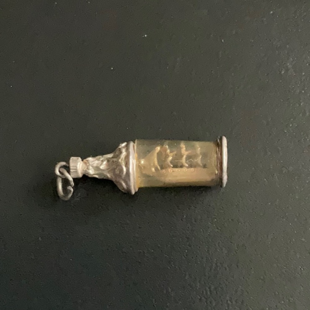 Very old silver ship in a bottle charm.